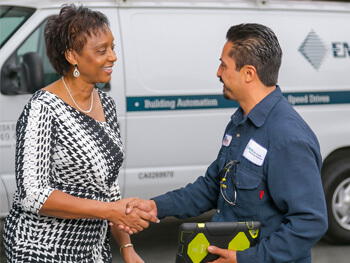 Mesa technician shaking hands with a client with a Mesa work vehicle in the background