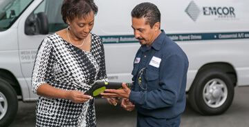 Mesa technician and client reviewing project details on a tablet 
