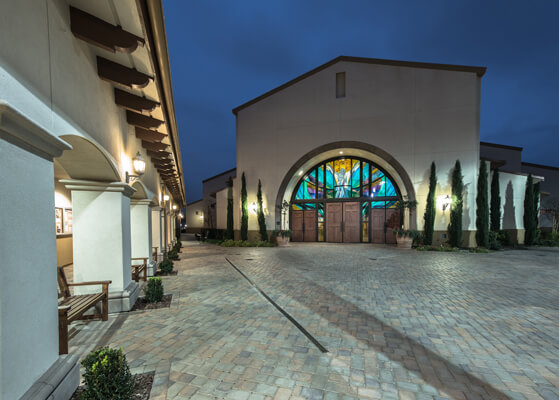Night view at St. Killian Catholic Church showcasing the exterior lights and stained glass